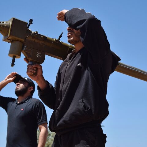 Rebel fighters monitor the sky holding a FN-6 man-portable air-defence system (MANPADS) in the Syrian village of Teir Maalah in 2016
